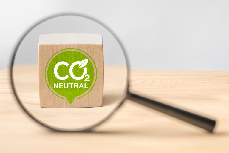 Vergrootglas dat een CO2-neutraal label controleert.